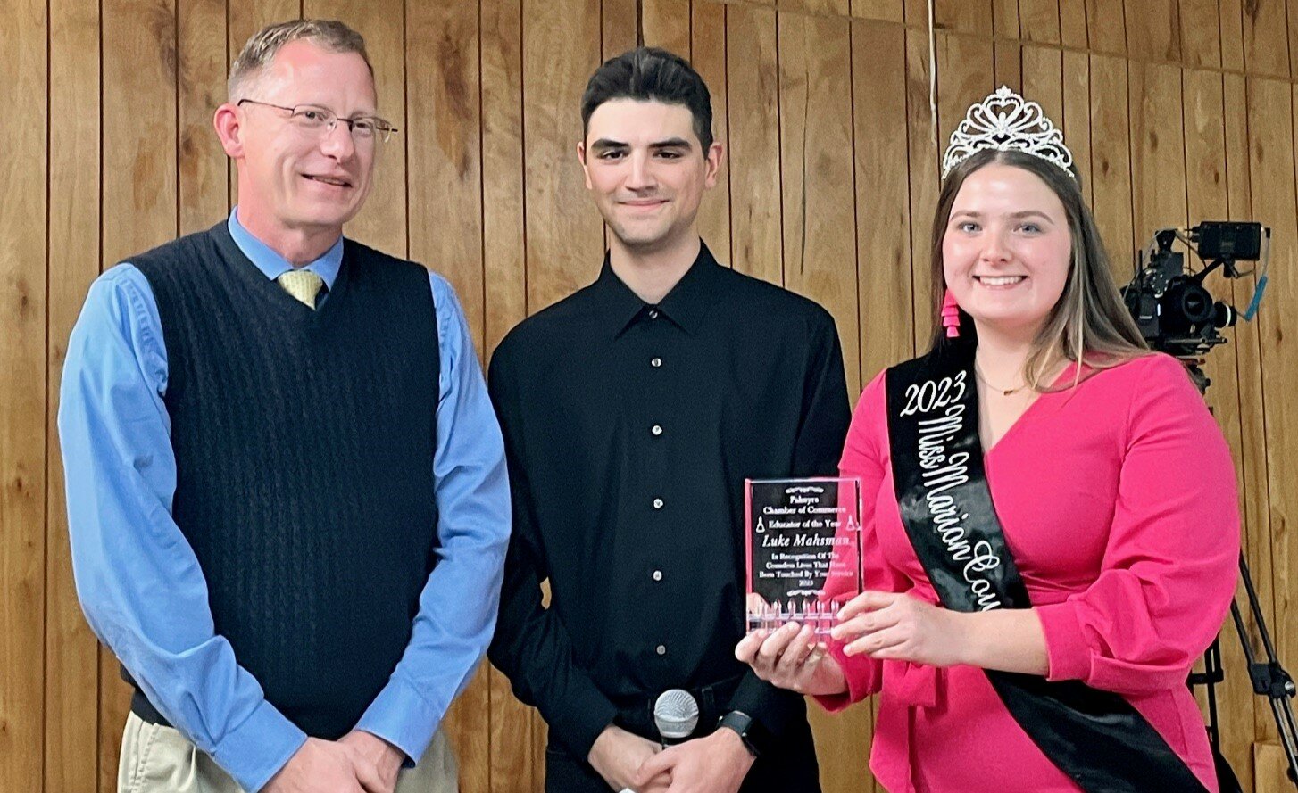 Elina Reed, the 2023 Miss Marion County, presents to Deacon Luke Mahsman, left, the Palmyra Chamber of Commerce’s 2023 Educator of the Year award on Jan. 11. With them is Tim Wellman, a former student of Deacon Mahsman, who introduced him at the award ceremony.